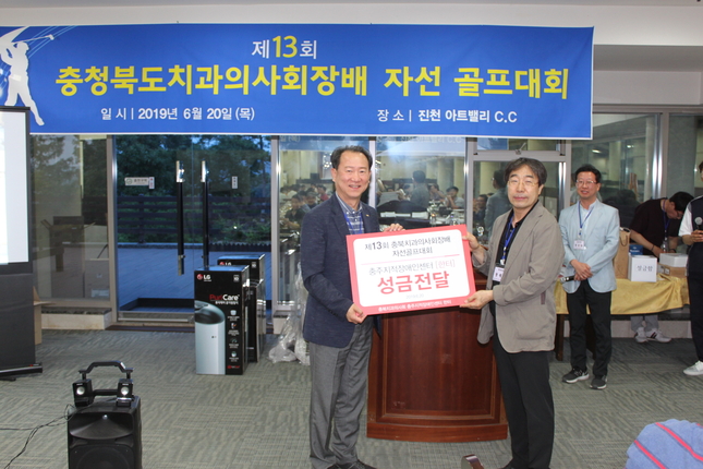 곽인주 충북지부 회장(사진 왼쪽)이 지적장애인센터 '한터'에 골프대회를 통해 모금한 성금을 전달했다.<충청북도치과의사회 제공>