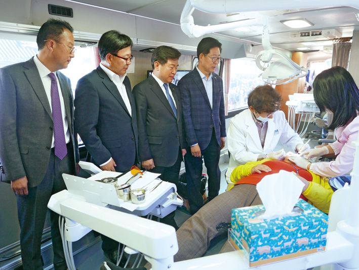 양승조 충남도지사, 김철수 협회장, 김영만 부회장, 박현수 충남지부 회장이 치과이동버스에서 장애우를 진료하는 의료진의 모습을 지켜보고 있다.<김용재 기자>