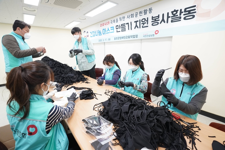 지난 17일 마스크를 제작하는 홍천국 장애인 근로작업장을 찾은 건보공단 직원들이 면 마스크 제작 봉사를 하고 있다.<건보공단 제공>