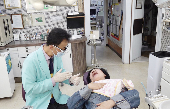 수어로 진료 중인 박우성 원장과 여경미 씨.<천민제 기자>