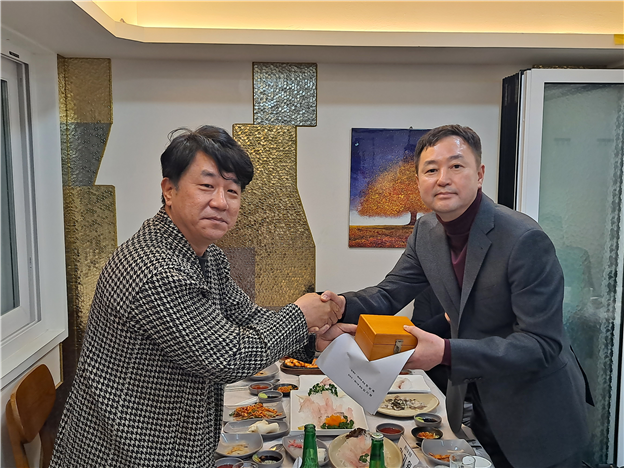 김기원 부산지부 신임 회장이 한상욱 전임 회장에게 회무 인수인계서를 전달 받았다.<부산지부 제공>