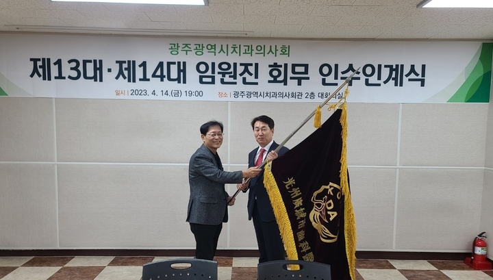 형민우 전 지부장이 박원길 신임 지부장(사진 오른쪽)에게 회기를 전달하고 있다. <광주지부 제공> 