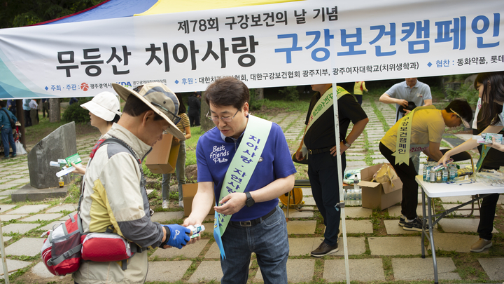 박원길 광주지부장이 무등산을 찾은 시민들을 대상으로 구강보건 캠페인을 벌이고 있다. <광주지부 제공>