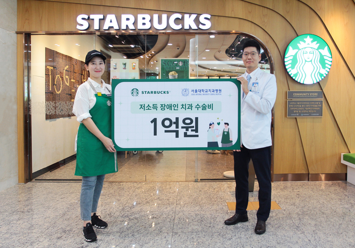 스타벅스 서울대치과병원점 최예나 점장(왼쪽)이 서울대치과병원 조정환 대외협력실장(오른쪽)에게 저소득 장애인 치과수술비 기금을 전달하고 있다.<서울대치과병원 제공>