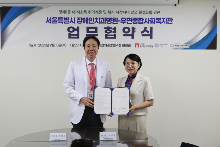 김성균 서울시 장애인치과병원장(좌측)과 이경희 우면종합사회복지관장(우측)이 지난 9월 13일 병원 4층 회의실에서 업무협약 후 기념촬영을 했다.<서울시 장애인치과병원 제공>