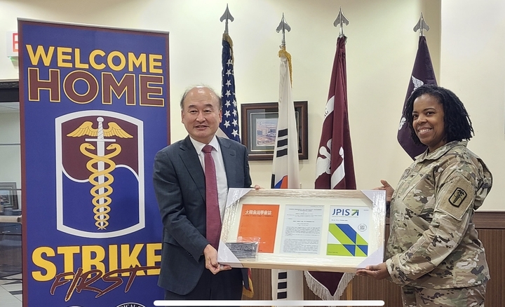 구 영 교수가 Utley 주한미군치과부대장에게 대한치주과학회지 창간호가 담긴 기념액자를 전달하고 있다. 