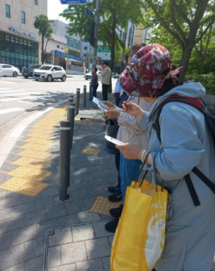 물티슈가 다량 들어 있는 노란 쇼핑백을 든 아르바이트생이 시민들에게 물티슈를 건네며 치과를 홍보하고 있다.<치의신보 DB>
