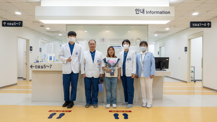 서광석 센터장(왼쪽에서 두 번째)과 유수연 교수(오른쪽에서 두 번째)를 비롯한 의료진이 내원 환자에게 꽃다발과 기념품을 전달하고 있다.