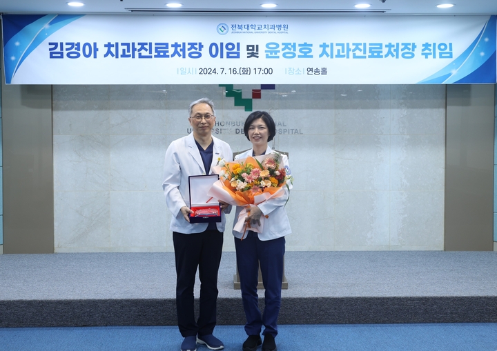 윤정호 신임 전북대치과병원 치과진료처장과 김경아 전임 치과진료처장이 기념촬영을 했다. <전북대치과병원 제공>