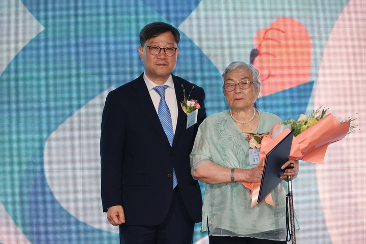 보건복지부 장관상을 수상한 김임식 어르신(사진 오른쪽)이 정윤순 보건의료정책실장과 기념촬영을 했다. <최상관 기자>