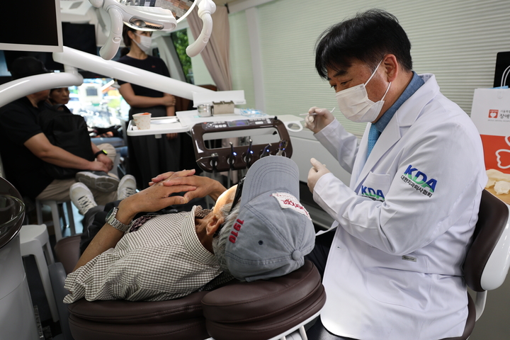 최종기 대외협력이사가 치협 이동치과병원에서 시민을 대상으로 구강검진을 하고 있다. <최상관 기자>