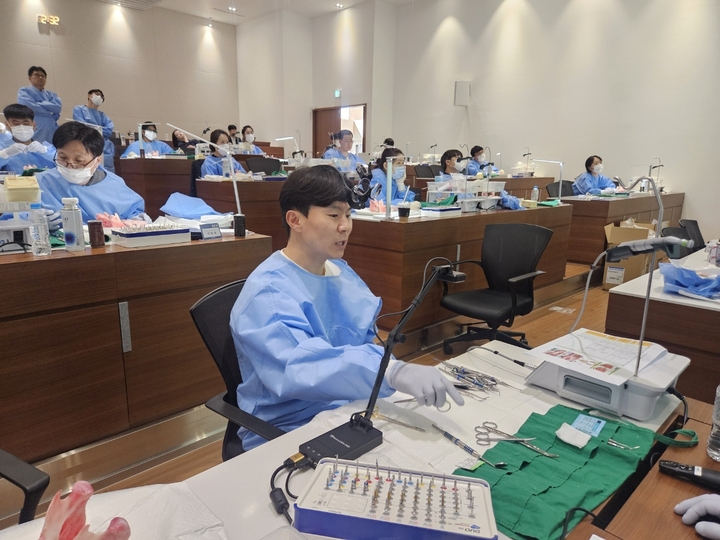 임현창 교수의 임플란트 식립 돼지 뼈 데모 시연 중 설명하고 있는 모습