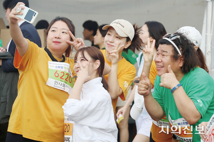 스마일 런 참가자가 연예인들과 기념사진을 찍고 있다.